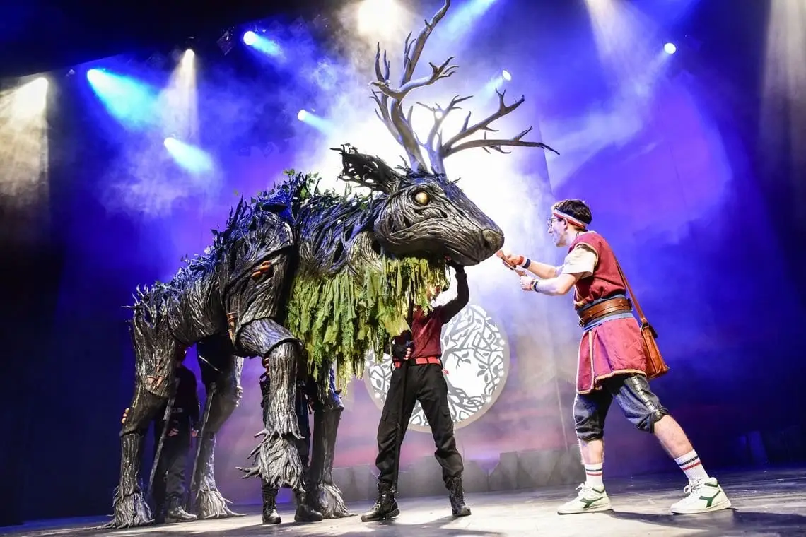 The antlered Indrik puppet with its handlers