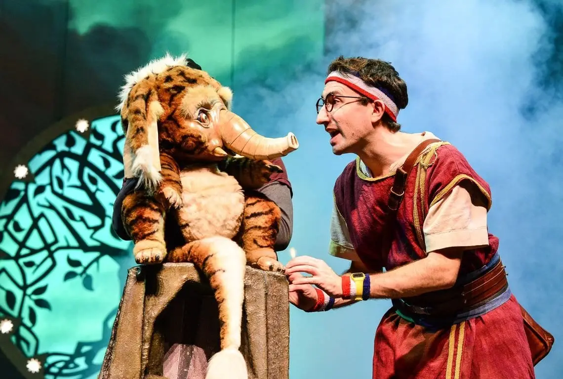 A hero kneels beside the Baku puppet