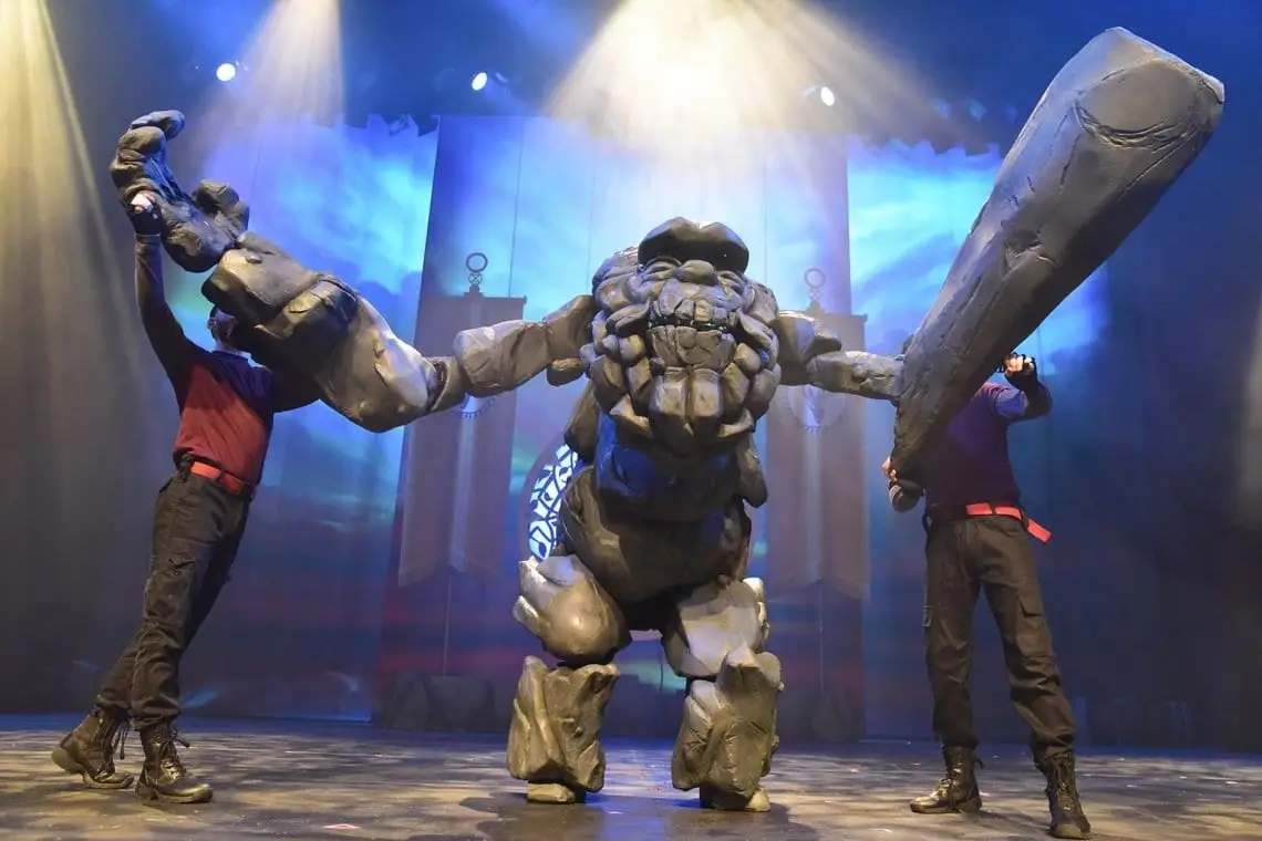 The Stone Troll towers over a performer