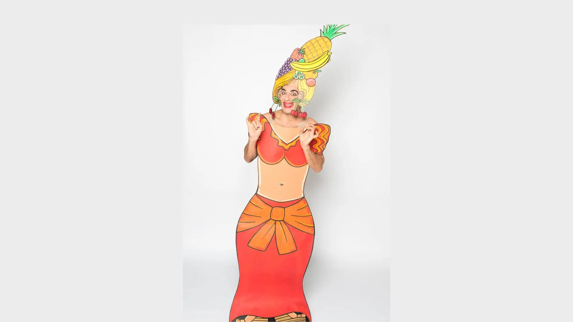 Ennio in a fruit-topped paper headdress and orange dress