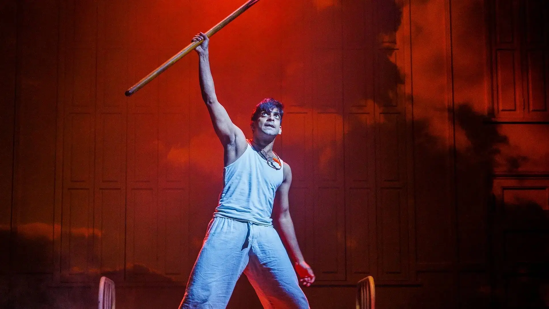 Pi holds a pole aloft against a stormy sky
