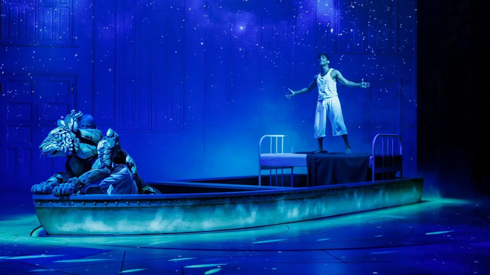 Pi standing on the lifeboat in a blue ocean of light