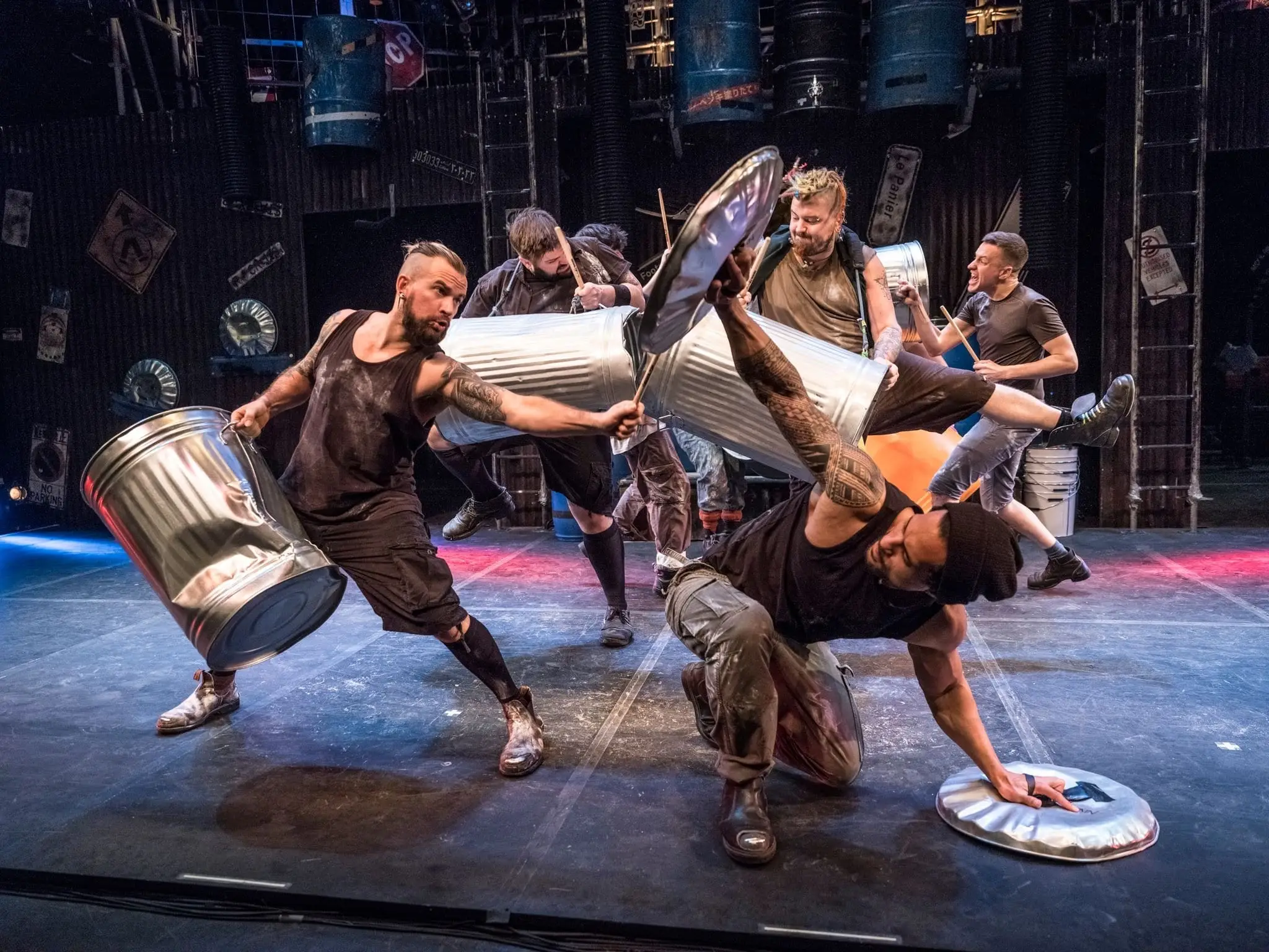 STOMP performers swinging metal dustbins