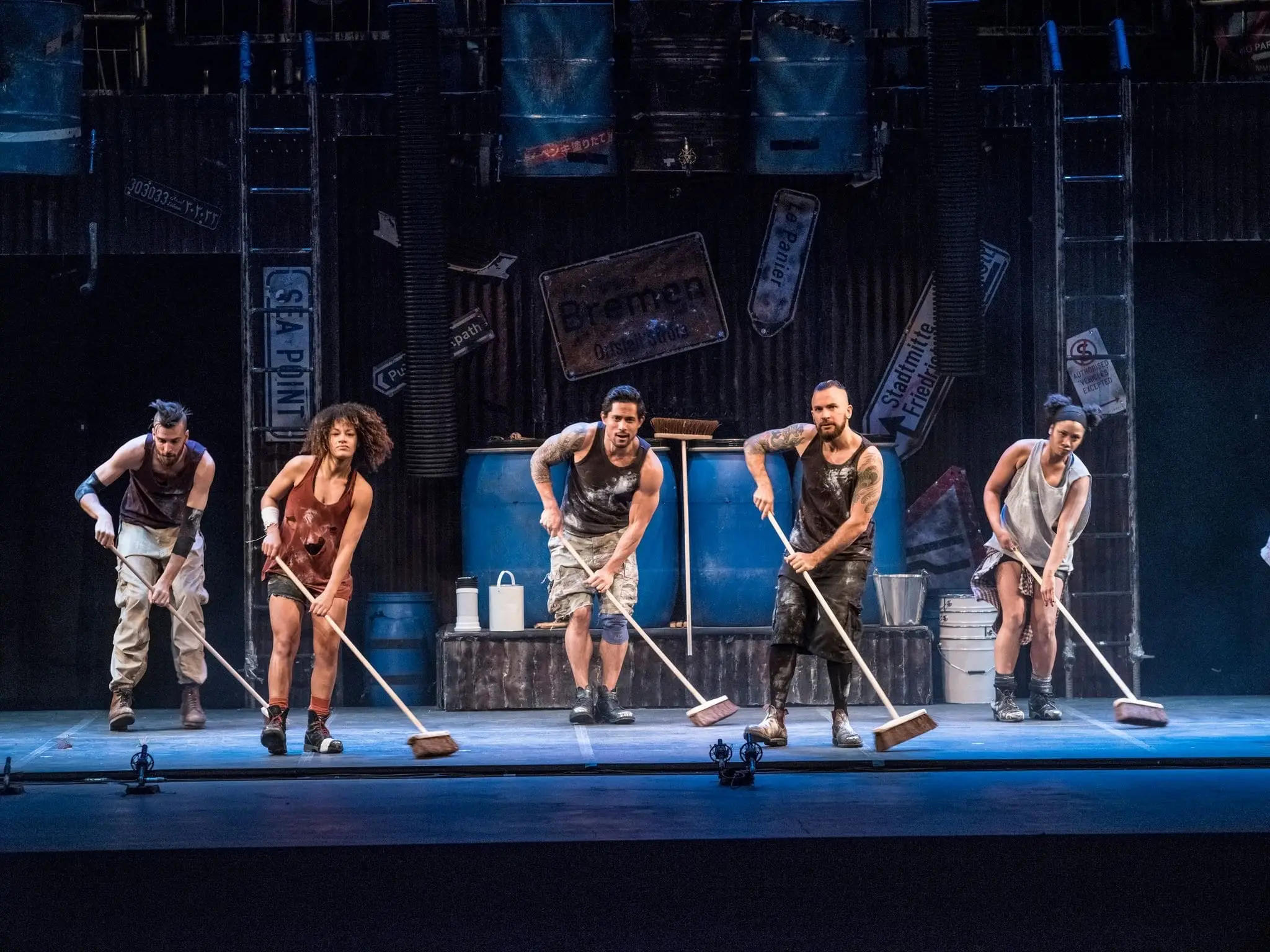 STOMP performers sweeping in rhythm with brooms