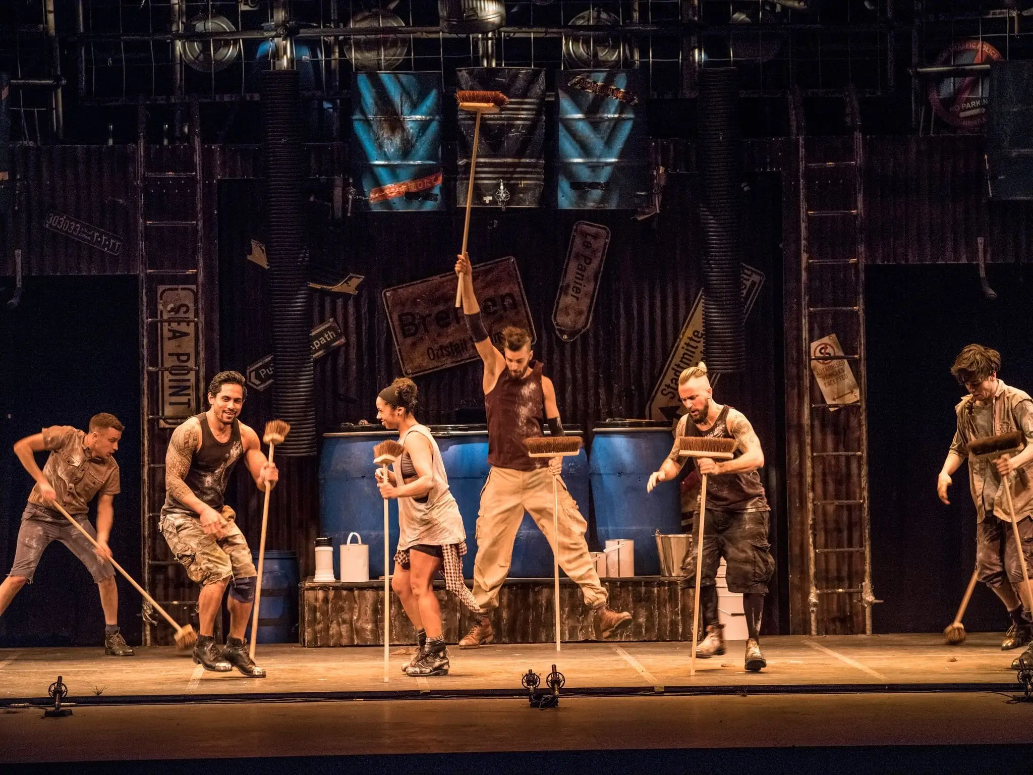 The company with brooms raised on the STOMP set