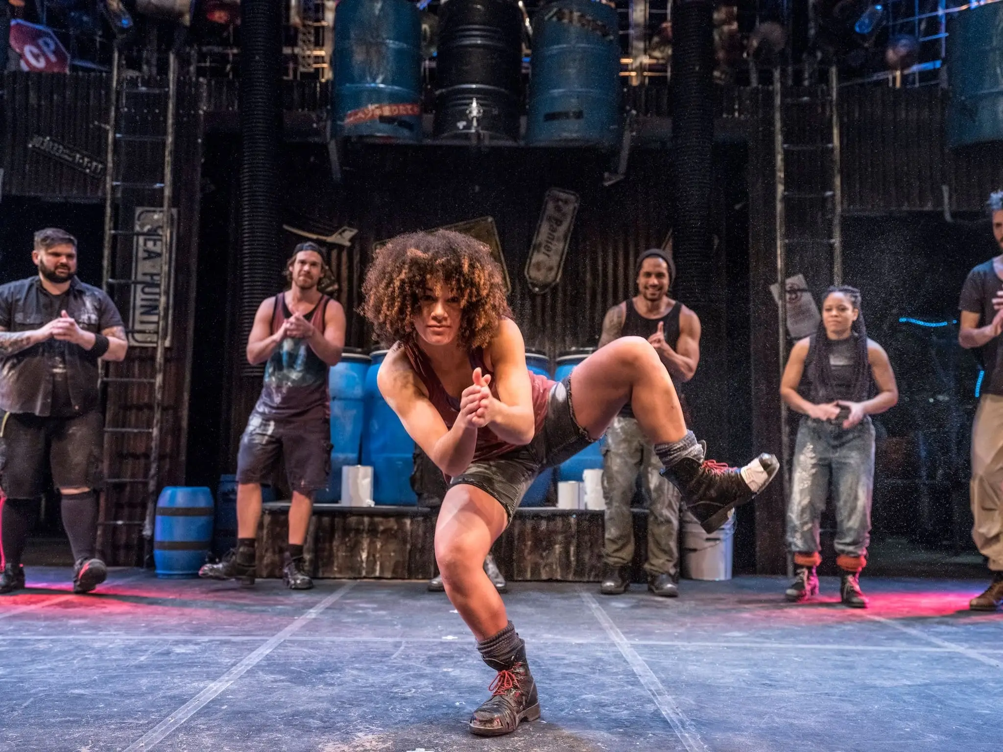 A STOMP performer crouched centre stage, the company behind