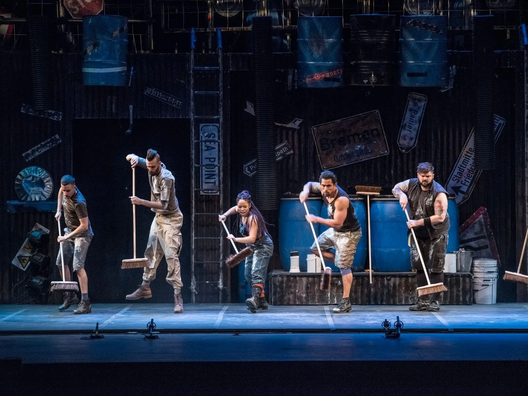 STOMP performers with brooms and paint tins
