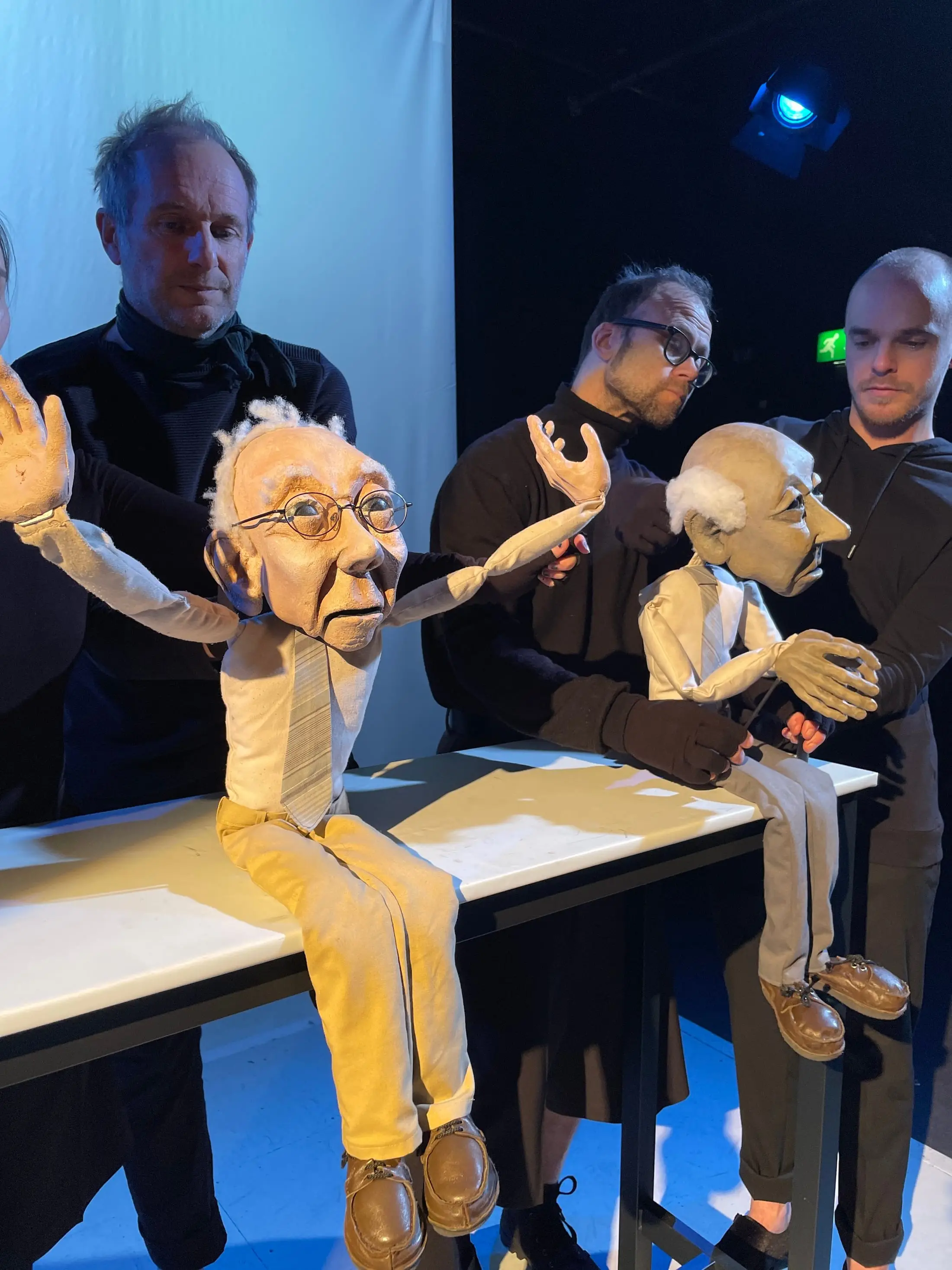 Two elderly puppets side by side at a table